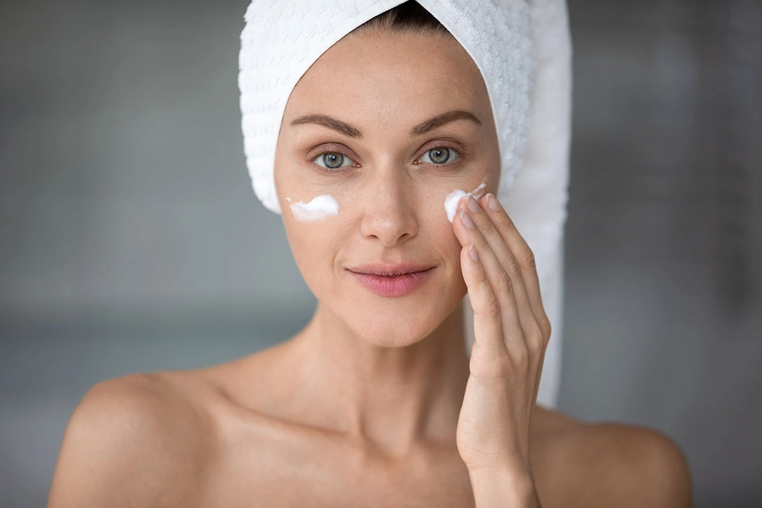 Linden-Apotheke - Pharmazeutische Dienstleistungen & Online-Bestellung - Werbung für die Hautpflege von Linola, die eine Frau mit einem Handtuch auf dem Kopf zeigt, die Gesichtscreme aufträgt.