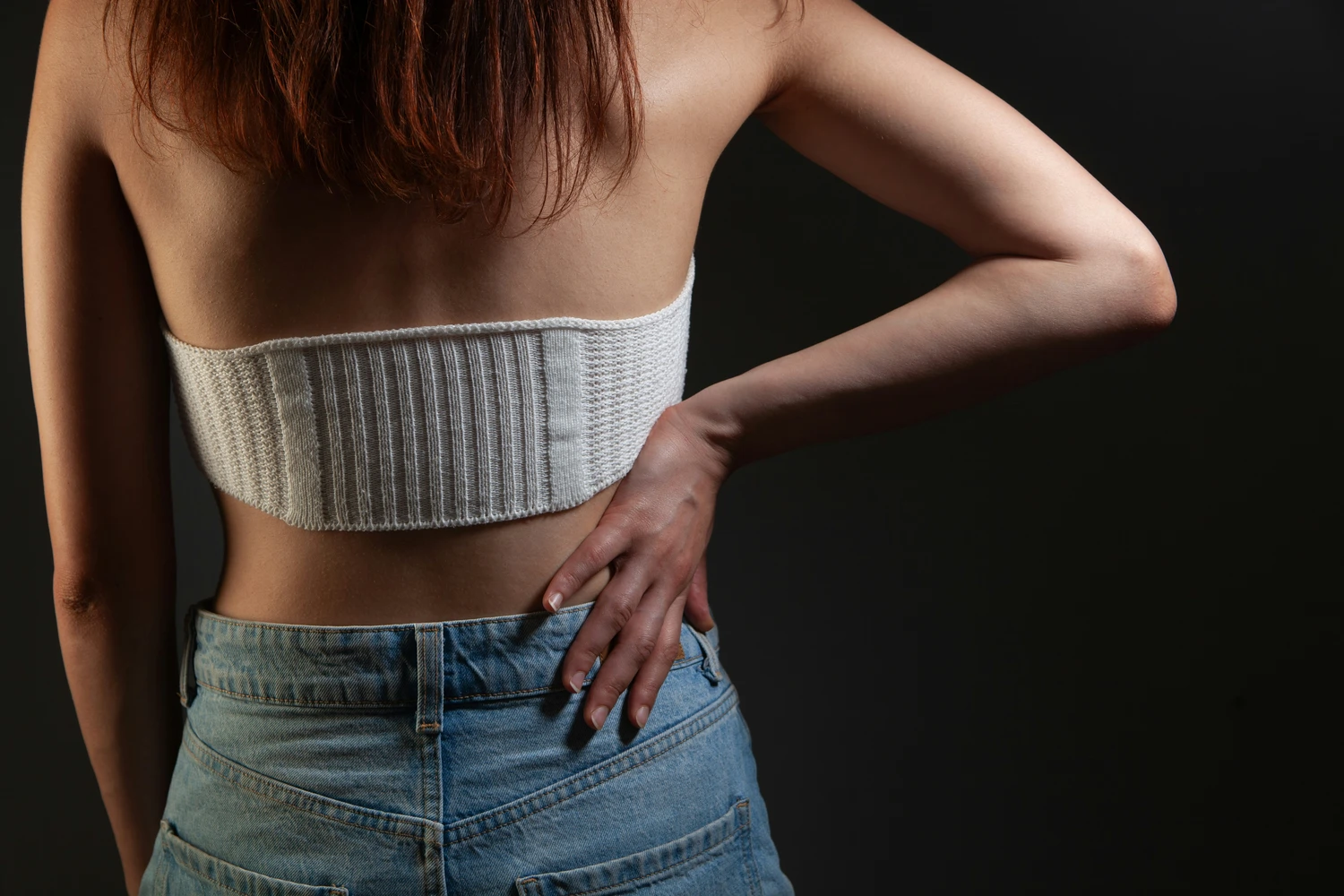 Linden-Apotheke - Pharmazeutische Dienstleistungen & Online-Bestellung - Rückansicht einer Person, die Blue Jeans und einen weißen gerippten ThermaCare-Wärmewickel über dem unteren Rücken trägt.